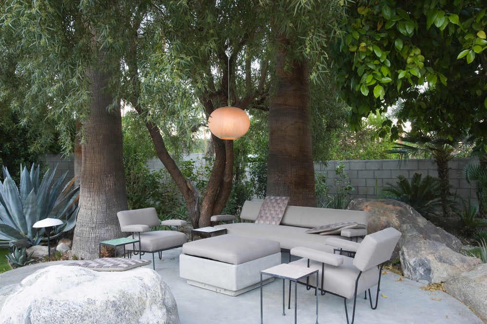 Outdoor concrete patio with couches and trees